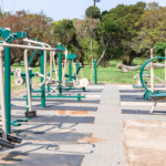 Outdoor gym setup with equipment in a sunny park, ideal for summer workouts.