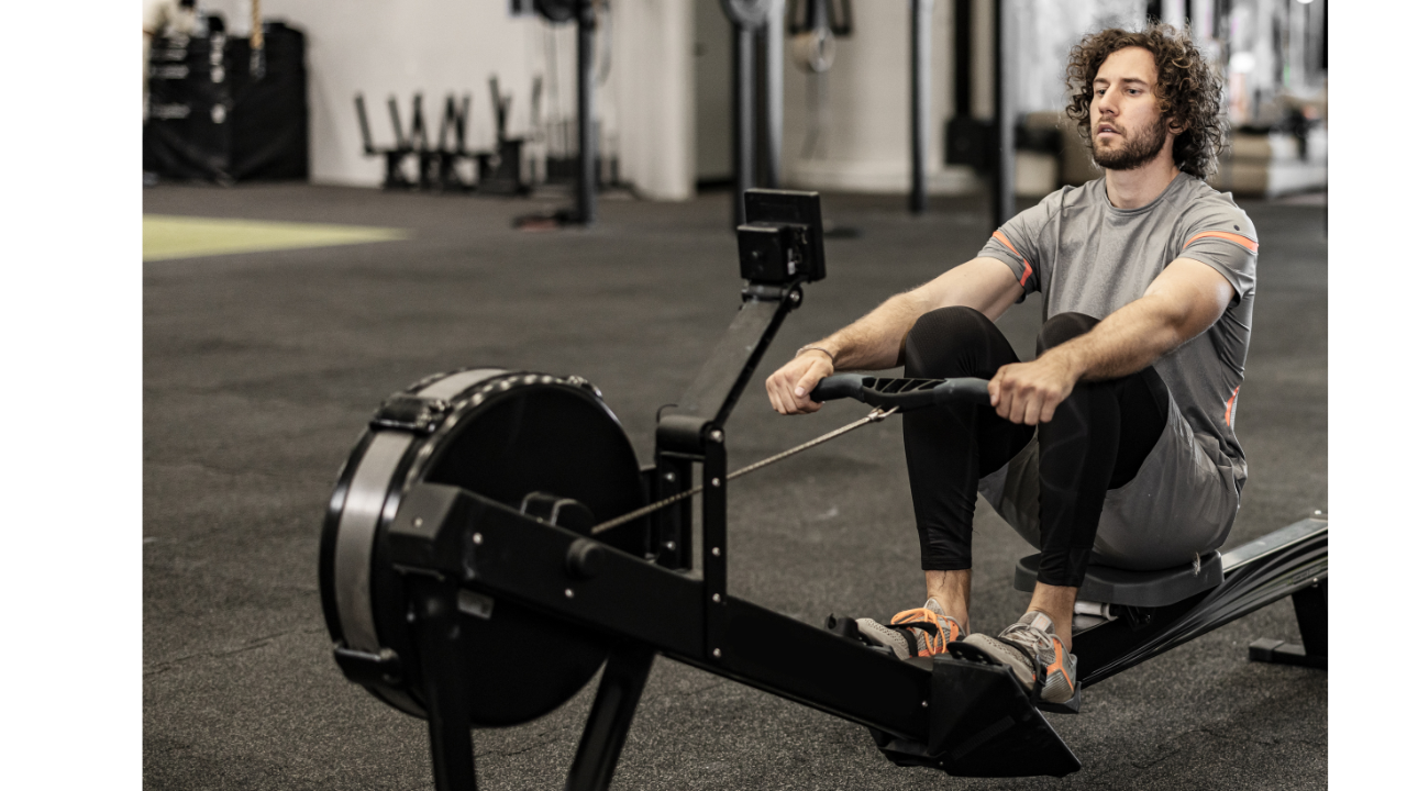 Person performing a rowing machine workout, showcasing proper technique and full-body engagement.