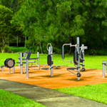 Person using outdoor gym equipment in a park setting for fitness training.