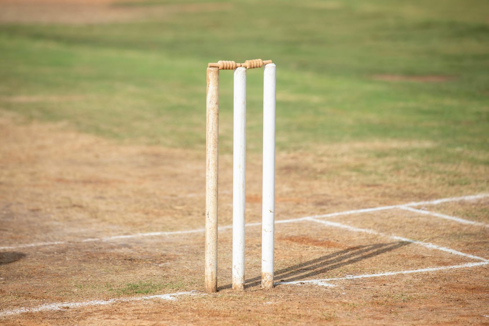 A comparison between artificial and natural cricket pitches showing the surface texture and material differences.